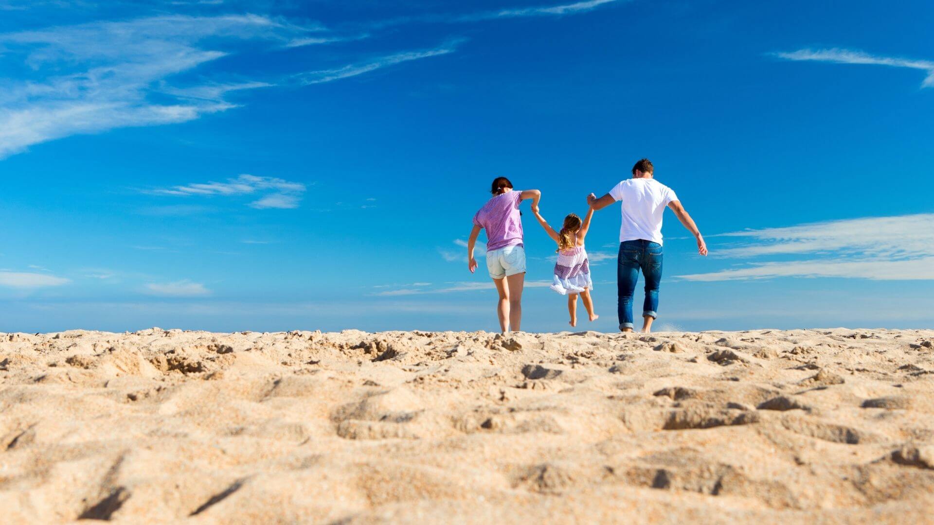 子育ての目的。仲良く海辺を歩く親子