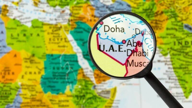 世界地図。虫眼鏡でUAE（アラブ首長国連邦）が拡大