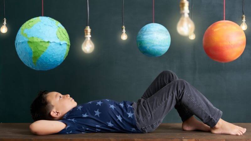 【NHK子ども科学電話相談】には地頭を良くする要素が満載。地球と衛生の模型を見上げる子ども
