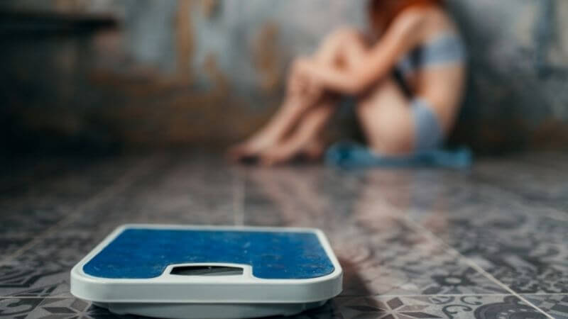 拒食症の少女と体重計